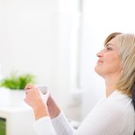 woman over 50 day dreaming with cup of coffee