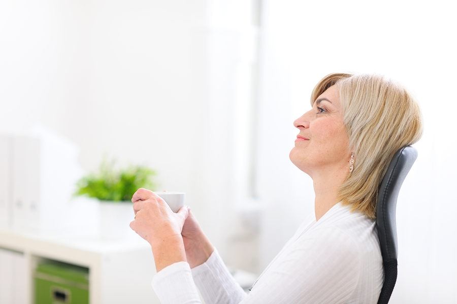 woman over 50 day dreaming with cup of coffee