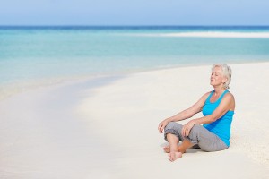 Senior-Woman-Meditating-On-Beach
