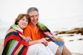 couple over 50 snuggling on the beach